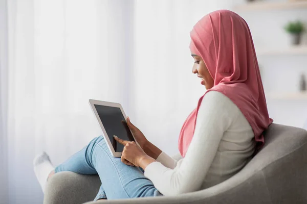 Afrikai nő Hidzsáb segítségével digitális tabletta fekete képernyő otthon — Stock Fotó