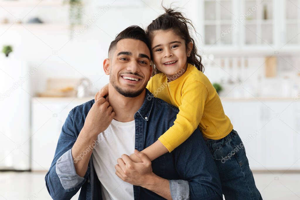 Portrait Of Happy Middle-Eastern Father And Little Daughter Posing In Kitchen Interior