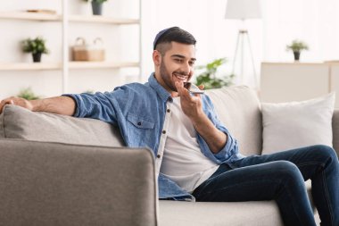 Mobil İletişim. Yahudi adam cep telefonunda ses asistanı kullanıyor.