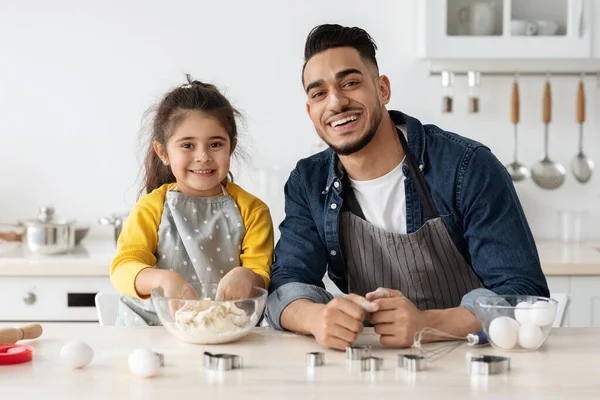 Šťastný arabský otec a malá dcera pečení sušenky v kuchyni spolu — Stock fotografie