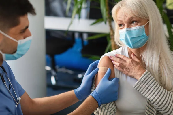 Olgun Kadın Covid-19 'a karşı aşı oluyor, Doktor Alçı Uygulıyor — Stok fotoğraf
