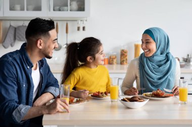 Yurtiçi Kahvaltı. Mutfakta birlikte yemek yiyen Orta Doğulu mutlu bir aile.
