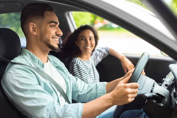 Glimlachende jonge man en vrouw uit het Midden-Oosten zittend in luxe auto — Stockfoto