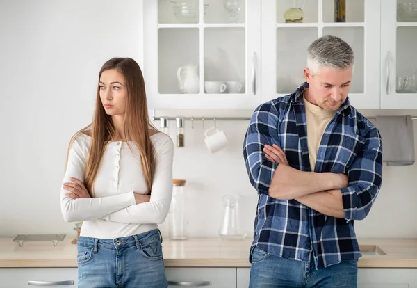 Uražený dospělý manželský pár stojící v kuchyni se zkříženými pažemi po hádce doma — Stock fotografie