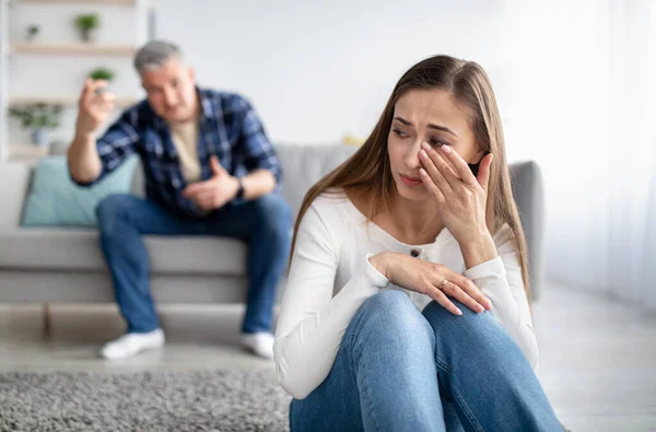 Reifer Mann missbraucht seine depressive Frau, schreit, demütigt und bedroht sie, Frau mittleren Alters weint zu Hause — Stockfoto