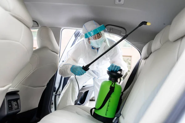 Spesialis pembersih mengenakan peralatan pelindung pribadi PPE menggunakan semprotan alkohol kimia — Stok Foto