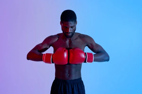 Portrait de boxeur noir motivé mettant des gants ensemble dans la lumière au néon. Concept sportif professionnel — Photo