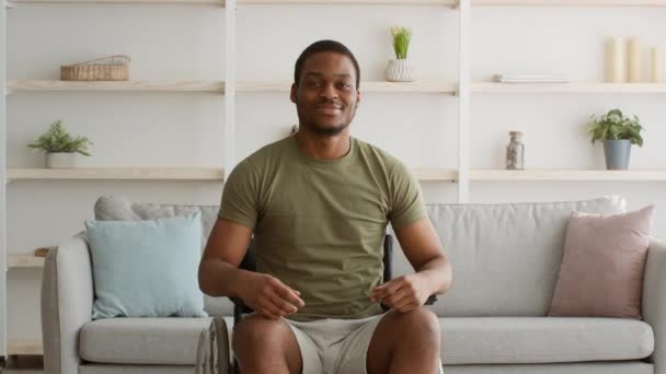 Gehandicapte Afro-Amerikaanse man in rolstoel tonen biceps poseren binnen — Stockvideo