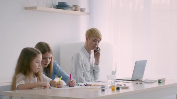 Çevrimiçi çalışan iki kızın annesi içeride telefonla konuşuyor. — Stok video