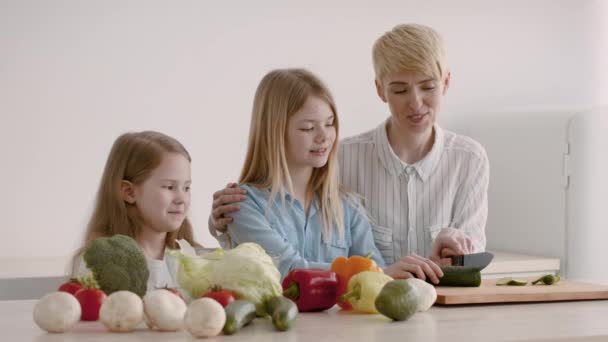 Filhas de ensino mãe para cozinhar preparando o jantar juntos na cozinha — Vídeo de Stock