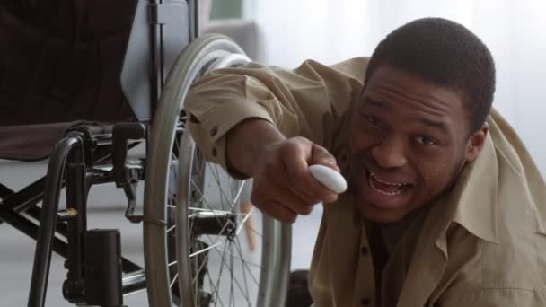Инвалид нажимает экстренную кнопку после падения с инвалидного кресла в помещении — стоковое видео