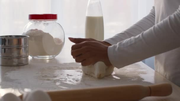 Pişirme işlemi. Mutfak masasında hamur yoğurup hamur işi hazırlayan tanınmamış siyahi kadını yakından çek. — Stok video