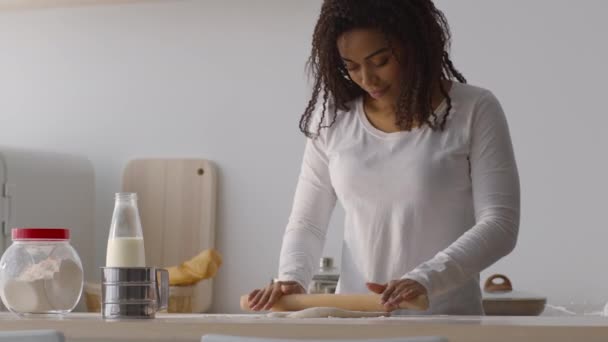 Молода афроамериканська домогосподарка готується до випічки вдома, розкручуючи тісто з шпилькою на кухні. — стокове відео