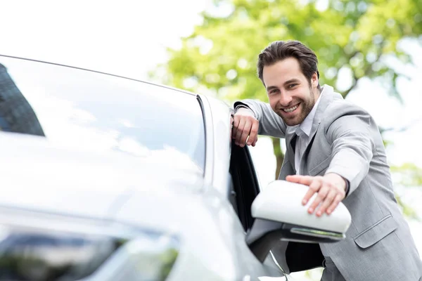 Vonzó elégedett öltönyös európai férfi megérinti az új szállítmányozást az autóboltban — Stock Fotó