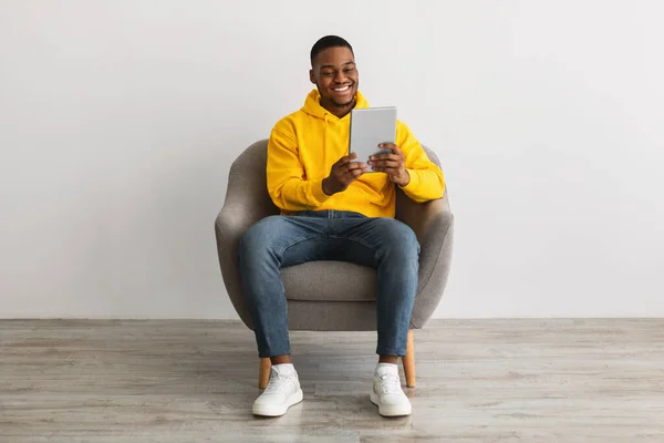 Hombre afroamericano usando tableta navegar por Internet sobre fondo gris —  Fotos de Stock