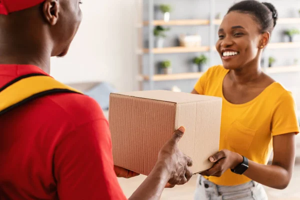 Zusteller liefert Paketkasten an Afrikanerin zu Hause — Stockfoto