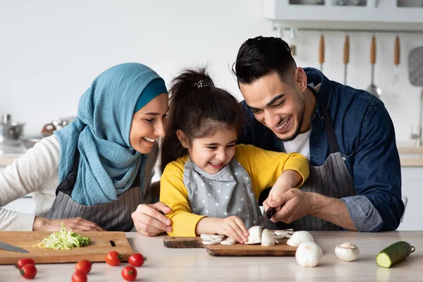 Neşeli Arap ebeveynler kızlarına sağlıklı yemek yapmayı öğretiyor. — Stok fotoğraf