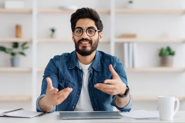 Portrait of positive arab man sitting in home office, talking at camera, cheerful advisor man sharing business ideas — Stock Photo, Image