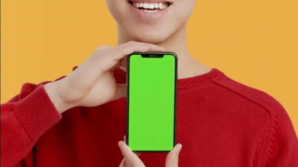 Αγνώριστος τύπος που παρουσιάζει Smartphone με Chroma βασική οθόνη, κίτρινο φόντο — Αρχείο Βίντεο