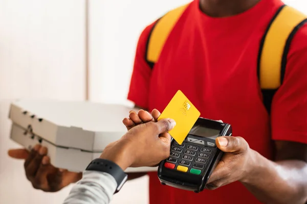 Courrier payant client méconnaissable mettant la carte de crédit au terminal à l'intérieur — Photo