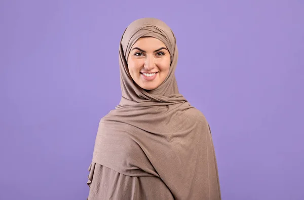 Portrait of beautiful armenian muslim woman in hijab over purple background, studio shot — Stok Foto