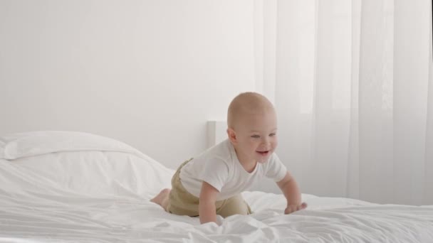 Roztomilé dítě plazit a lezení z postele doma — Stock video