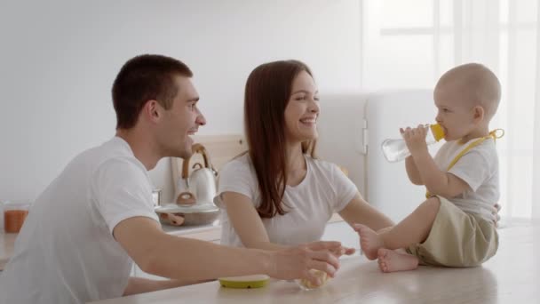 Loving Young Parents Spending Time With Their Infant Baby In Kitchen — Stok Video