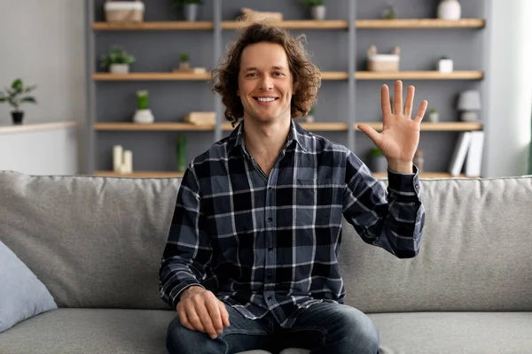 Hombre positivo saludando a Hello In Greeting Gesto sentado en casa — Foto de Stock