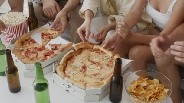 Χέρια διαφορετικών νέων που παίρνουν νόστιμες φέτες ιταλικής πίτσας από το κουτί — Αρχείο Βίντεο