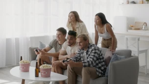 Wielokulturowa grupa przyjaciół urządzająca imprezę, grająca w gry wideo w domu — Wideo stockowe