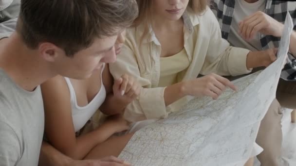 Viajar juntos. Grupo de jóvenes amigos multiétnicos que tienen mapa de la ciudad, planificación de vacaciones — Vídeos de Stock