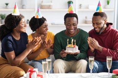 Neşeli siyah gençler evde erkek doğum gününü kutluyorlar.