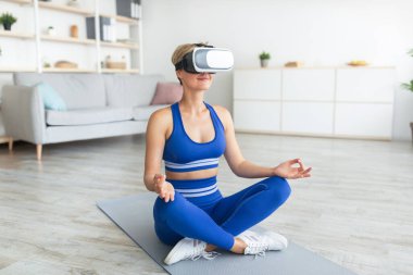 VR kulaklıklı kadın lotus pozunda oturmuş meditasyon yapıyor.
