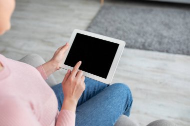 Web siteniz ya da uygulama reklamınız için boş ekranlı tablet bilgisayar kullanan genç bayan.