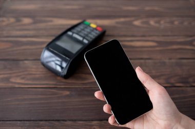 Modern kolay NFC teknolojisi kullanarak akıllı telefondan ulaşılamayan bir bayan, cep telefonunu boş siyah ekranla tutuyor.
