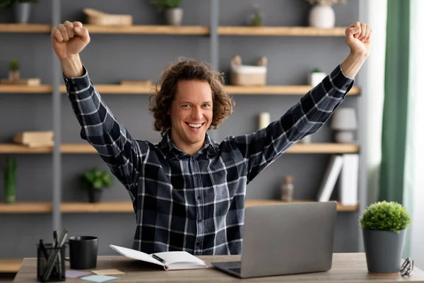 Empresario agitando puños en alegría mirando a la computadora portátil en la oficina — Foto de Stock