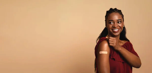 Mulher americana africana feliz mostrando ombro após a vacinação, panorama — Fotografia de Stock