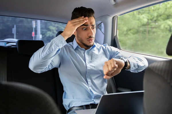 Besorgter arabischer Geschäftsmann schaut im Auto auf Uhr — Stockfoto
