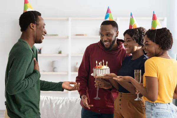Happy black friends making surprise for birthday guy