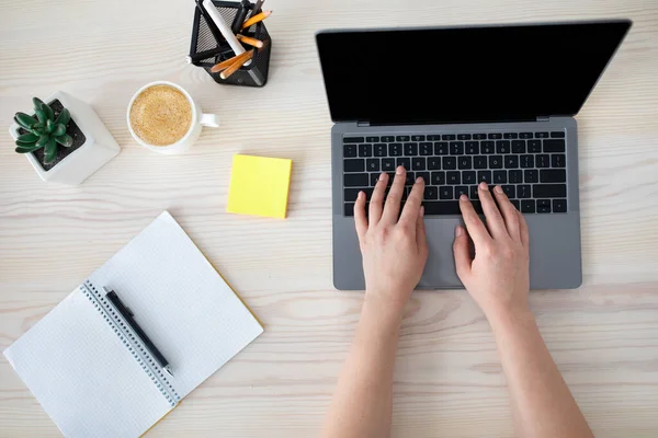 Posto di lavoro. Donna digitando sulla tastiera del computer portatile e note di scrittura, seduto alla scrivania, vista dall'alto, mockup, spazio copia — Foto Stock