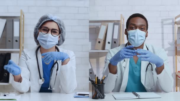 Dos médicos diversos en máscaras protectoras hablando con la cámara en la oficina, mujer y hombre africano grabación video blog n — Vídeo de stock