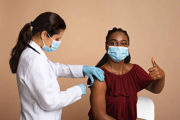 Ung svart kvinna i ansiktsmask blir vaccinerad — Stockfoto