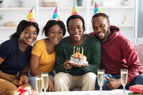 Group of happy black friends having birthday celebration at home