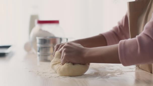 自家製パンを作る。未認識の女の子の手の近くに生の生地を混練,キッチンでベーカリーデザートを準備 — ストック動画