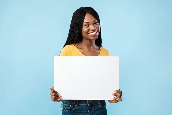 Positivo afro-americano fêmea mostrando vazio papel placa, fundo azul — Fotografia de Stock