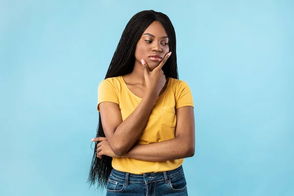 Thoughtful Black Millennial Woman Thinking Touching Chin Over Blue Background