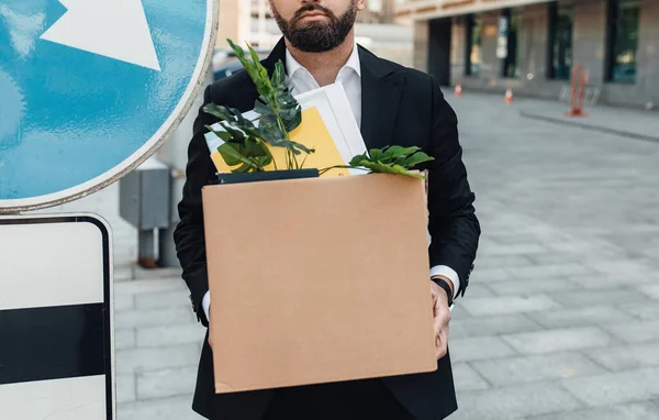 Homme d'affaires sans emploi debout avec une boîte de choses à l'extérieur, près de la signalisation routière, a perdu son emploi, culture — Photo