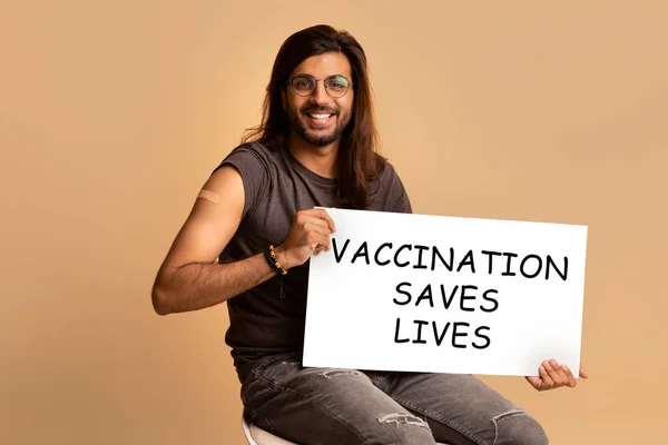 Vrolijke arabische jongen hipster werd gevaccineerd, houden motiverende boord — Stockfoto