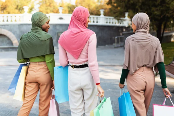 Dışarıdan alışveriş yaptıktan sonra çantalarla dolaşan üç Müslüman kadın. — Stok fotoğraf