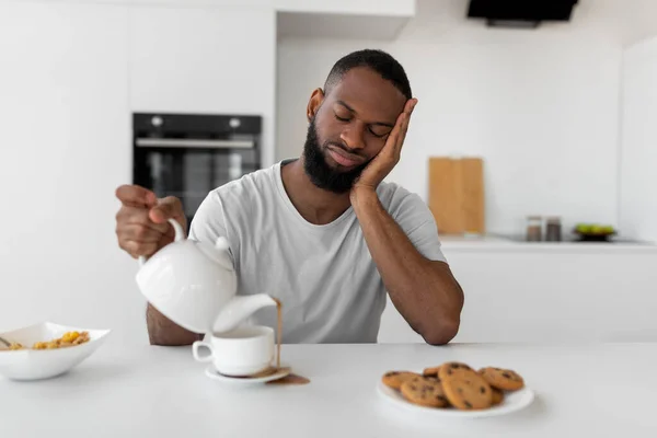 Zwarte man gieten koffie weg van kopje morsen warme drank — Stockfoto